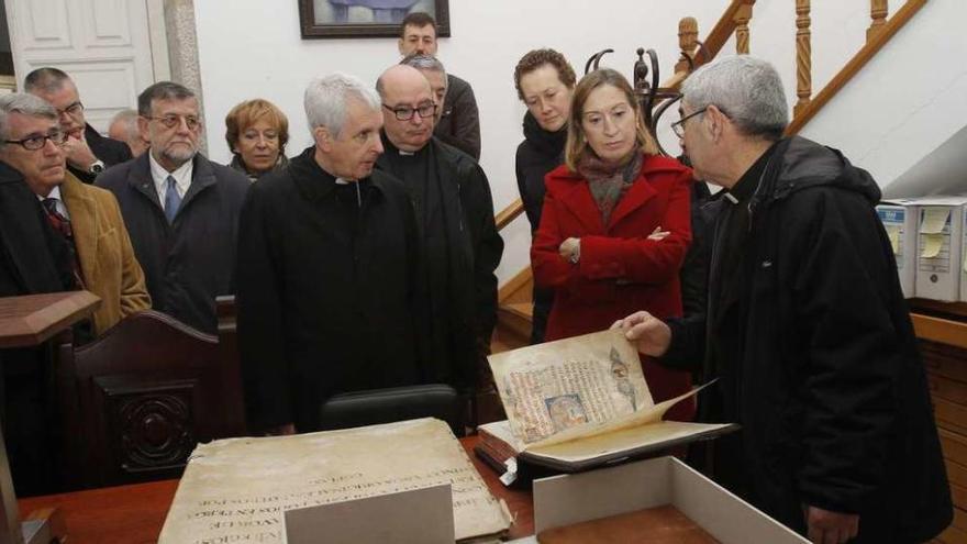 La ministra Ana Pastor, con el obispo, el deán y el canónigo, observando un códice en el archivo. // A. Irago