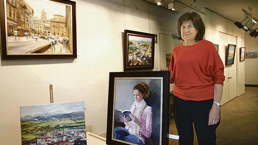 La artista Mercedes Blázquez, ayer, con varios de los cuadros expuestos en la Sala BBVA de Oviedo.