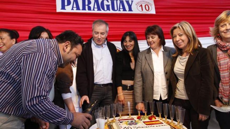 Los paraguayos celebran con las autoridades el décimo aniversario de la Trobada de Pobles con una tarta.