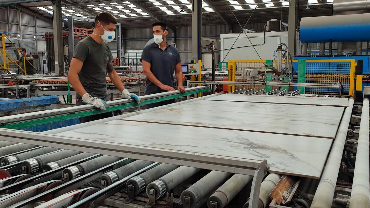 Dos trabajadores con azulejos de gran formato en una empresa de Castellón.