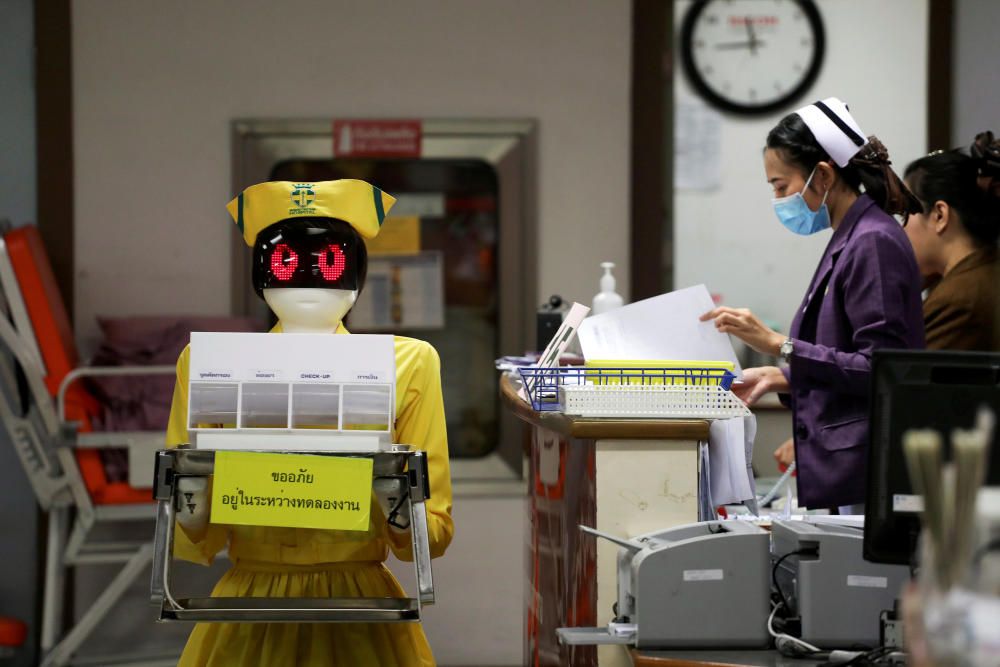 A robot wearing a nurse costume carries medical ...