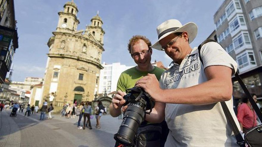 Dos holandeses miran las fotos que acaban de tomar del santuario de la Virgen Peregrina.  // Gustavo Santos