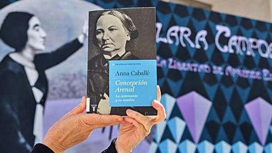 Marián Suárez, amb el llibre sobre Concepción Arenal i davant del grafiti de Clara Campoamor.