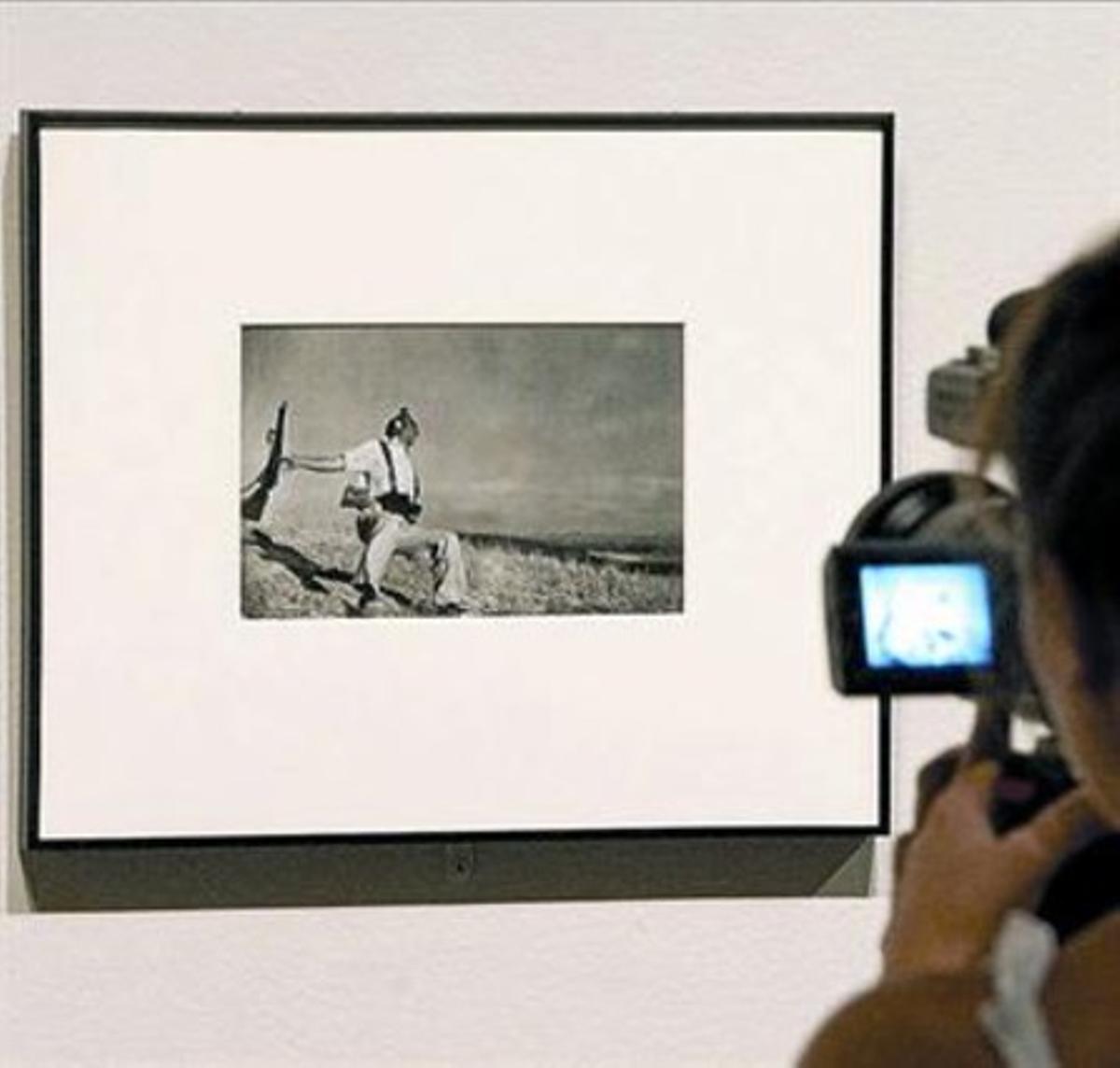 Un visitant capta imatges de la fotografia de Capa, al MNAC. Un visitant capta imatges de la fotografia de Capa, al MNAC.