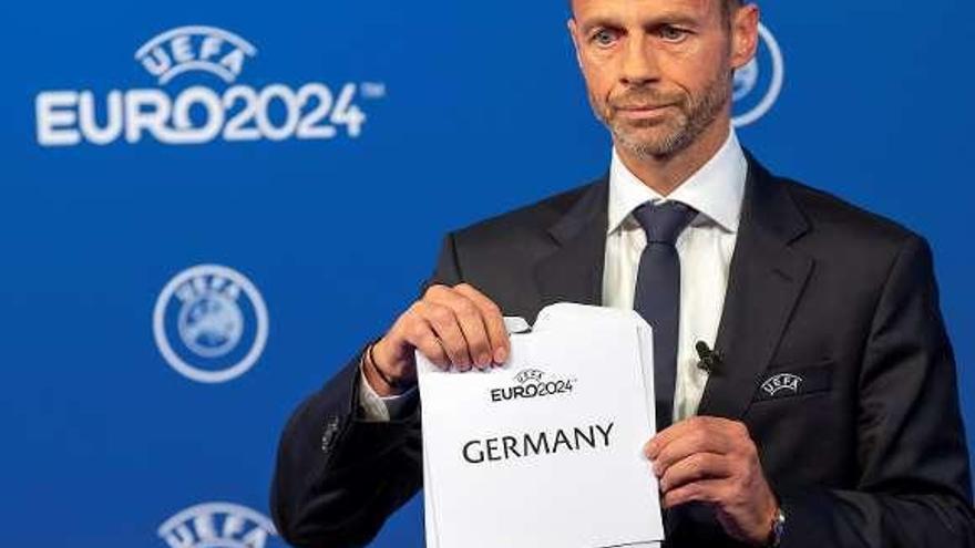 Alexander Ceferin muestra el cartel con la elección de la UEFA. // Efe