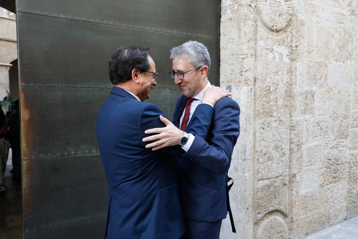 Arcadi España, conseller de Hacienda, se abraza con su antecesor en el cargo, Vicent Soler, antes del traspaso de carteras el pasado mes de mayo.