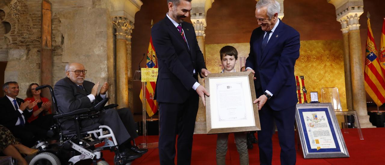 Gabriel Tirado, Jorge y Javier Sada sostienen el reconocimiento de la Medalla de las Cortes para Aspanoa,