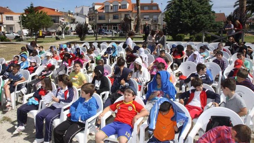 Los niños acudieron a la actividad intergeneracional que les mostró productos y recetas como antes, en la playa de Porto Meloxo.