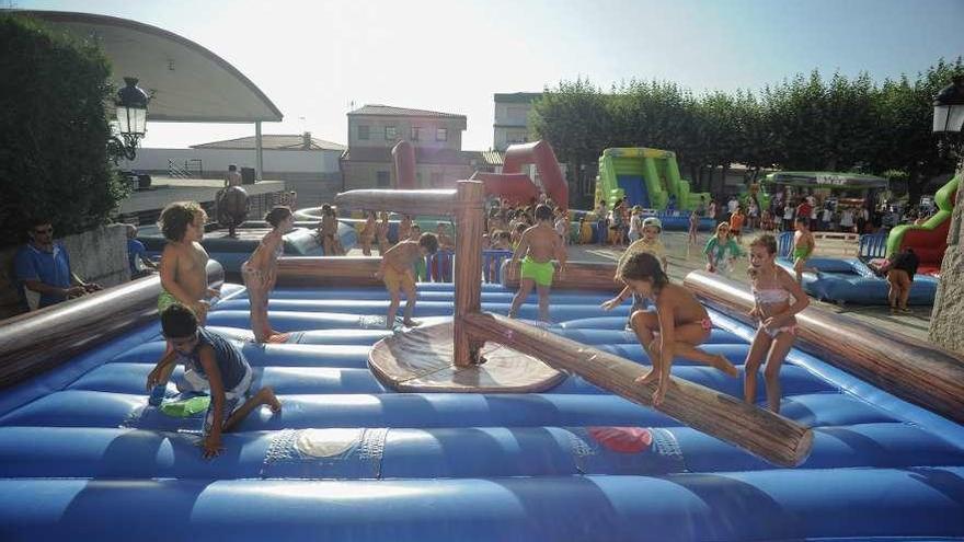 Los niños se entretienen en la plaza da Feira de Meaño en un día tórrido.  // Iñaki Abella