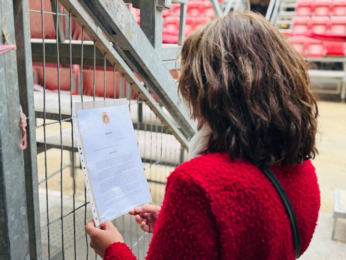 Una lorquina lee el Bando colocado en las tribunas.