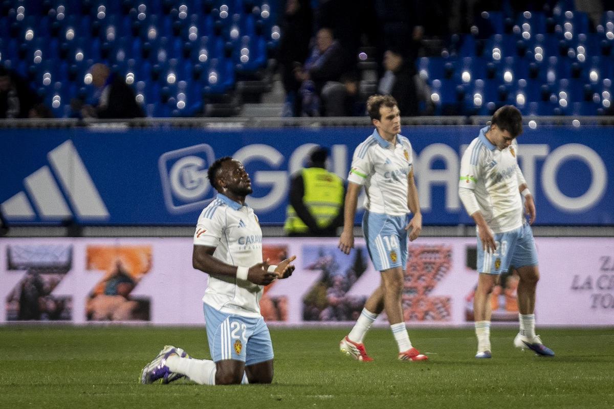 Agada, que debutó el sábado en el Zaragoza, reza al final del partido, con Francho y Aguirregabiria al lado.