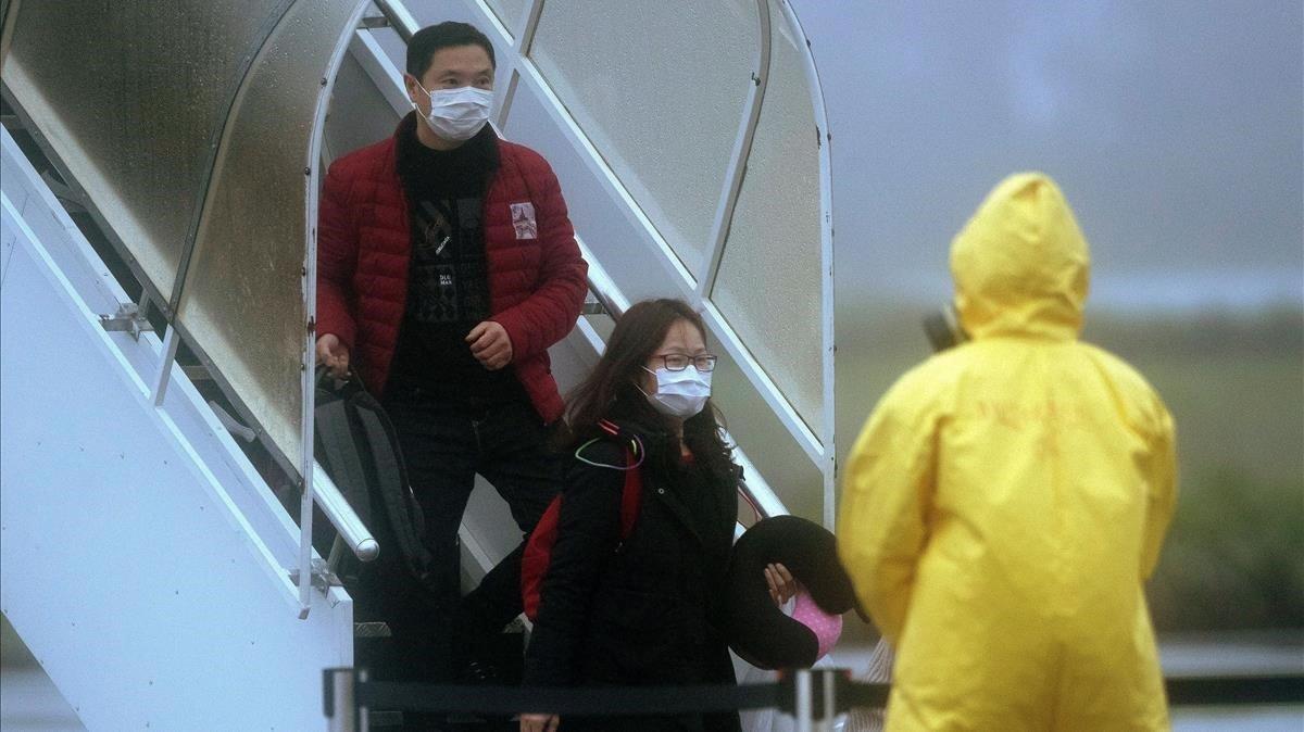 Pasajeros salen de los dos aviones fletados por el Gobierno de Brasil con 34 brasilenos y sus parientes repatriados de la ciudad china de Wuhan, el domingo.