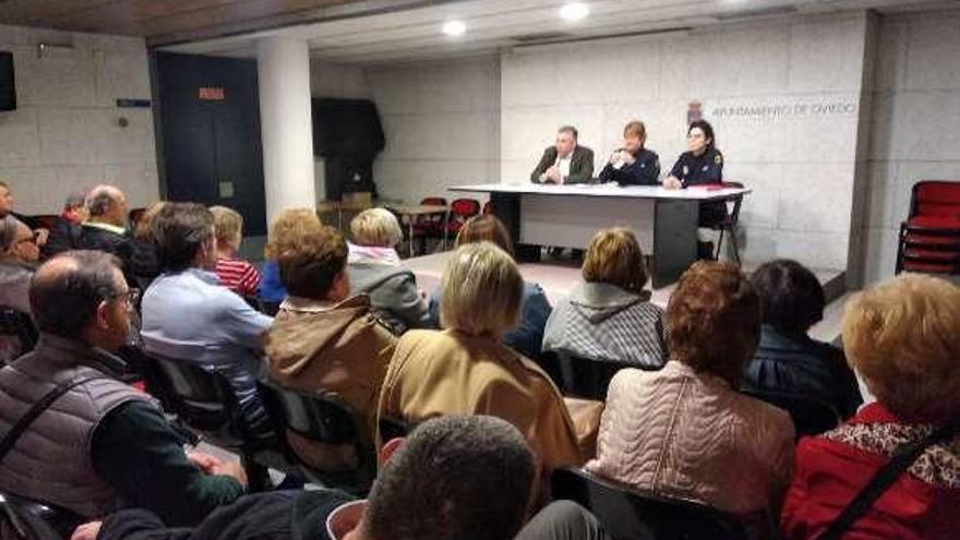 Los asistentes a la reunión escuchan a las agentes Isabel Gómez y Carmen Ingelmo y al presidente de Ciudad Naranco Existe, Rubén Fernández.