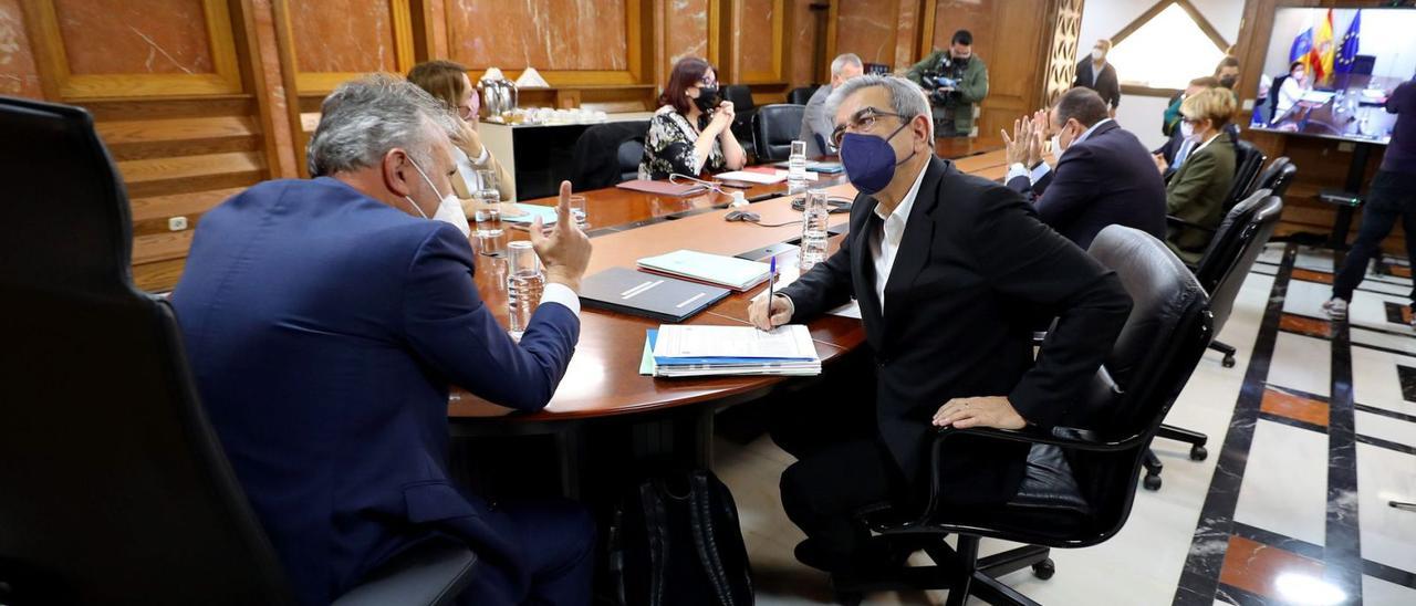 El presidente Ángel Víctor Torres, de espaldas, habla con el vicepresidente Román Rodríguez en el Consejo de Gobierno celebrado ayer en la capital grancanaria.