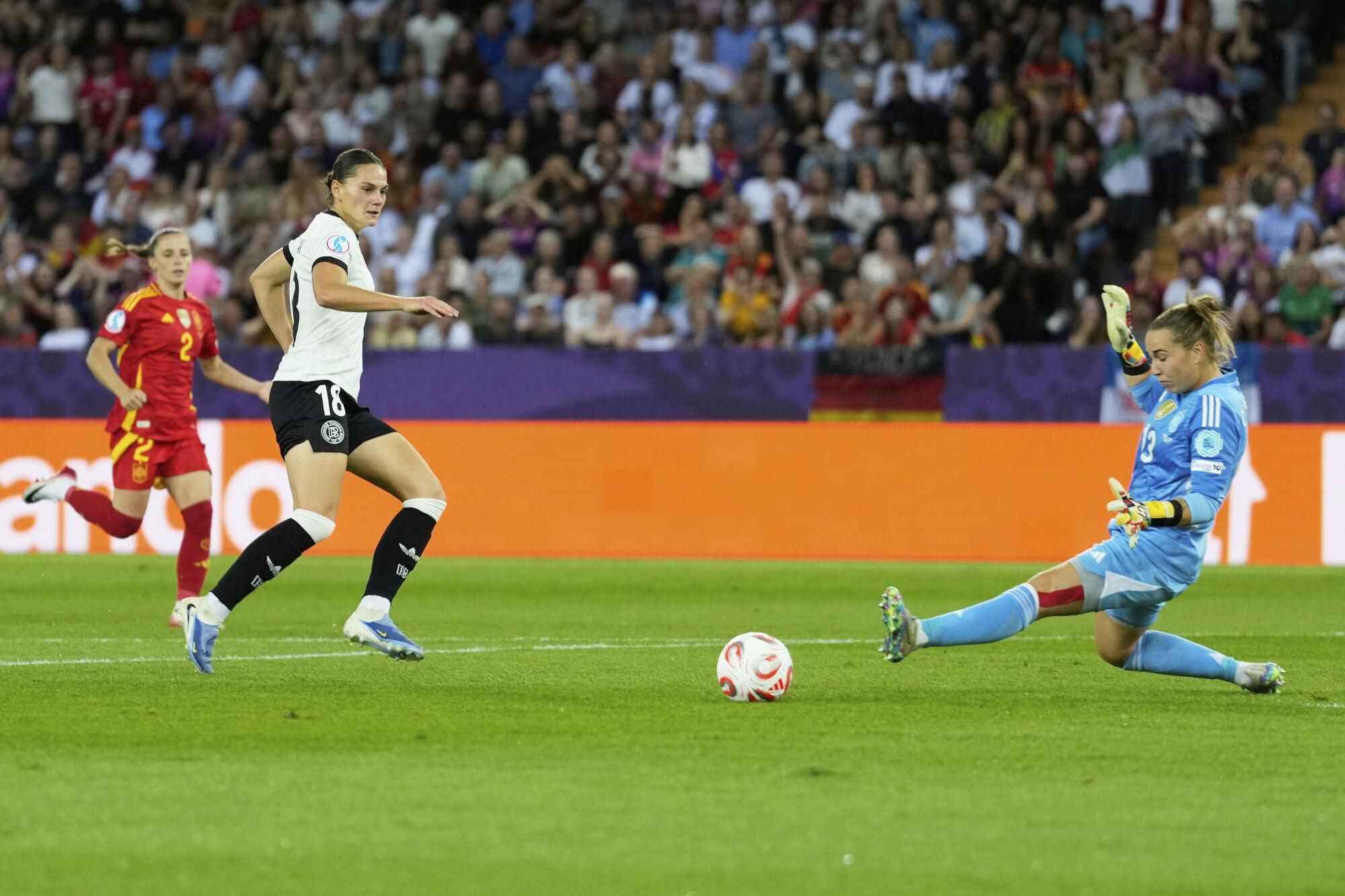 Germany's Giovanna Hoffmann, 2nd left, attempts a shot at goal past Spain goalkeeper Catalina Coll during the Women's Euro 2025 semifinals soccer match between Germany and Spain at Stadion Letzigrund in Zurich, Switzerland, Wednesday, July 23, 2025. (AP Photo/Alessandra Tarantino)