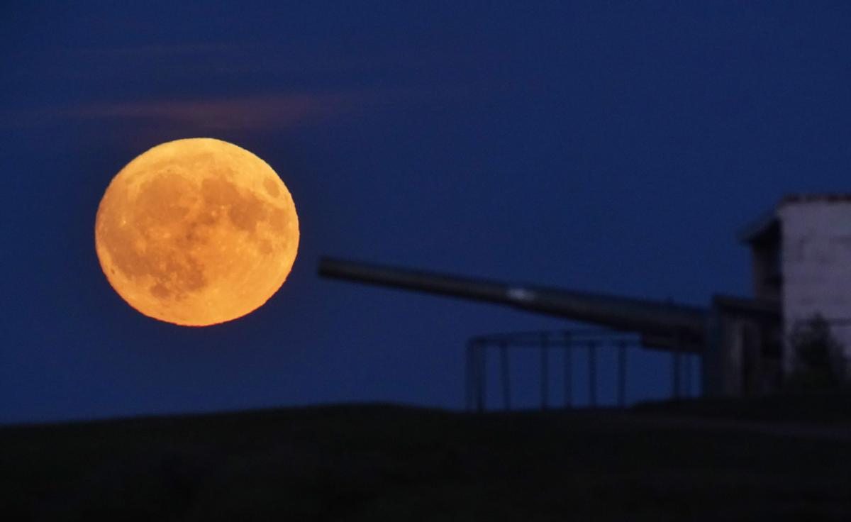 La Superluna de ciervo vista sobre un cañón en Blyth Battery en Northumberland, Inglaterra.