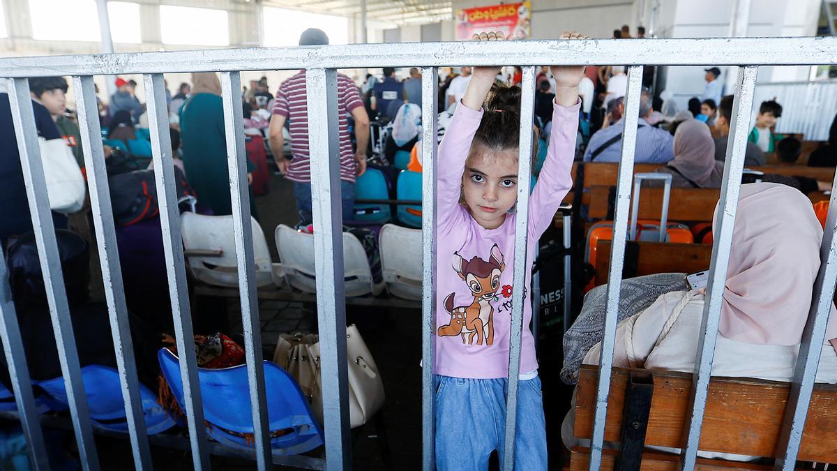 Palestinos con doble ciudadanía esperan en el cruce fronterizo de Rafah con Egipto