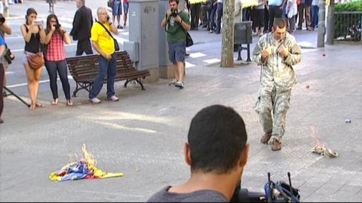 Un hombre quema una 'estelada' ante el monumento a Rafael Casanova