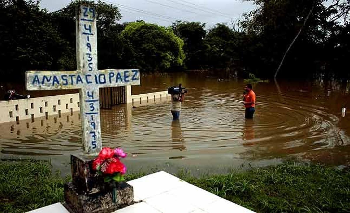 Un equip de notícies de la televisió retransmet un reportatge des del cementiri inundat del Llano (Panamà).