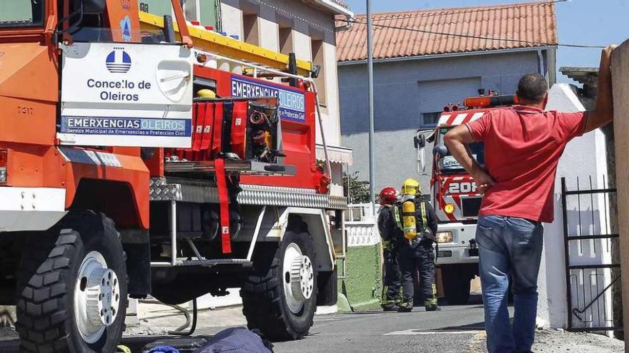 Bomberos delante de la casa que ardió en Mera.