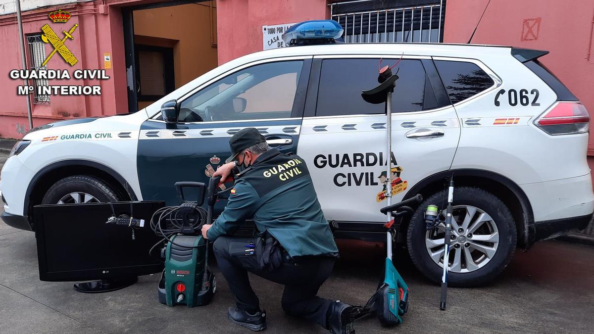 Un guardia civil con parte del material robado en la vivienda