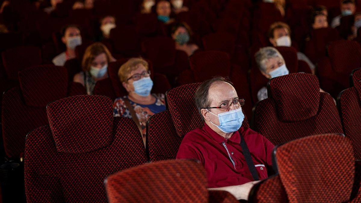 Aficionados al cine, ataviados con mascarillas y respetando la distancia, en una sala de Barcelona, el 26 de junio