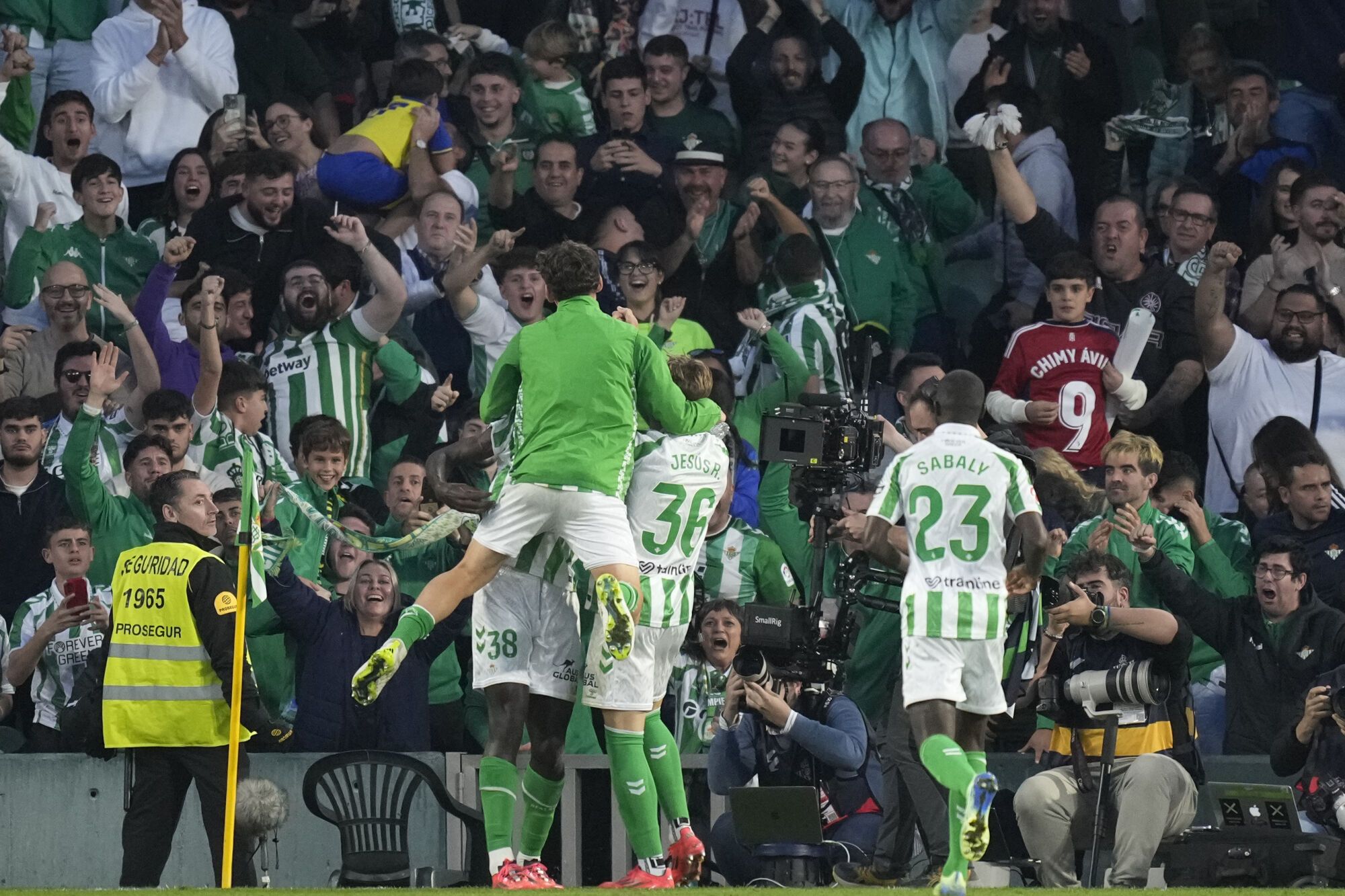 Real Betis players celebrate after Betis' Assane Diao scored his side's second goal during a Spanish La Liga soccer match between Betis and Barcelona at the Benito Villamarin stadium in Seville, Spain, Saturday, Dec. 7, 2024. (AP Photo/Jose Breton). EDITORIAL USE ONLY/ONLY ITALY AND SPAIN