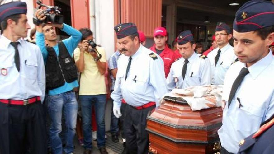 Compañeros portan el féretro a su salida del parque de bomberos donde se ofició la misa.  // E.G.