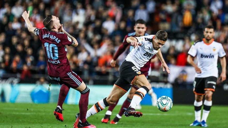 Aspas recibe un golpe en la cara mientras Paulista trata de marcharse con el balón, ayer en Mestalla. // Carla Cortés/LOF