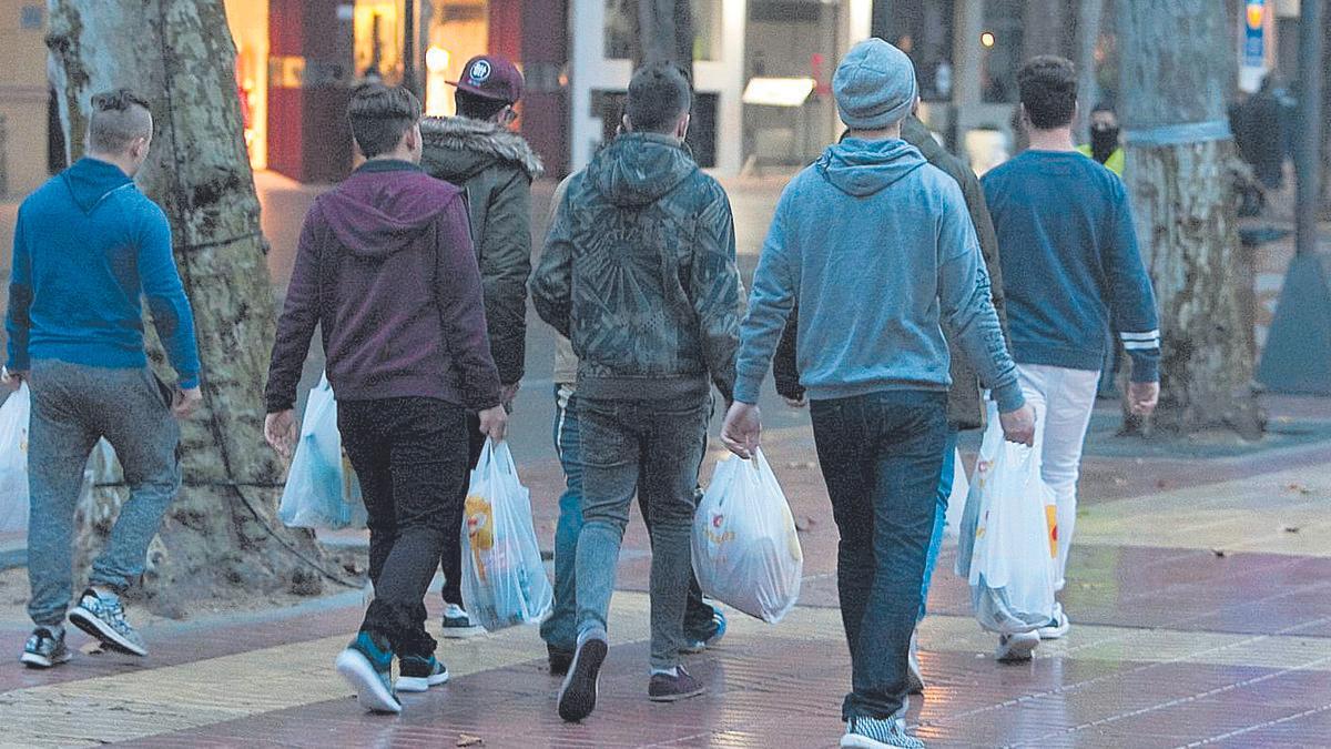 Un grupo de jóvenes, camino de un botellón con bolsas de bebida en una imagen de archivo.