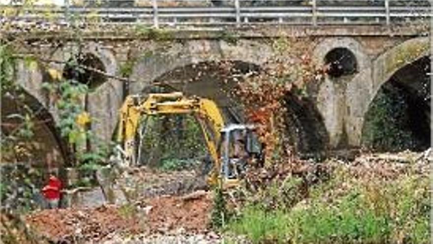 Els treballs seguien ahir a la riera, amb el pont de la Gi-555 al fons.