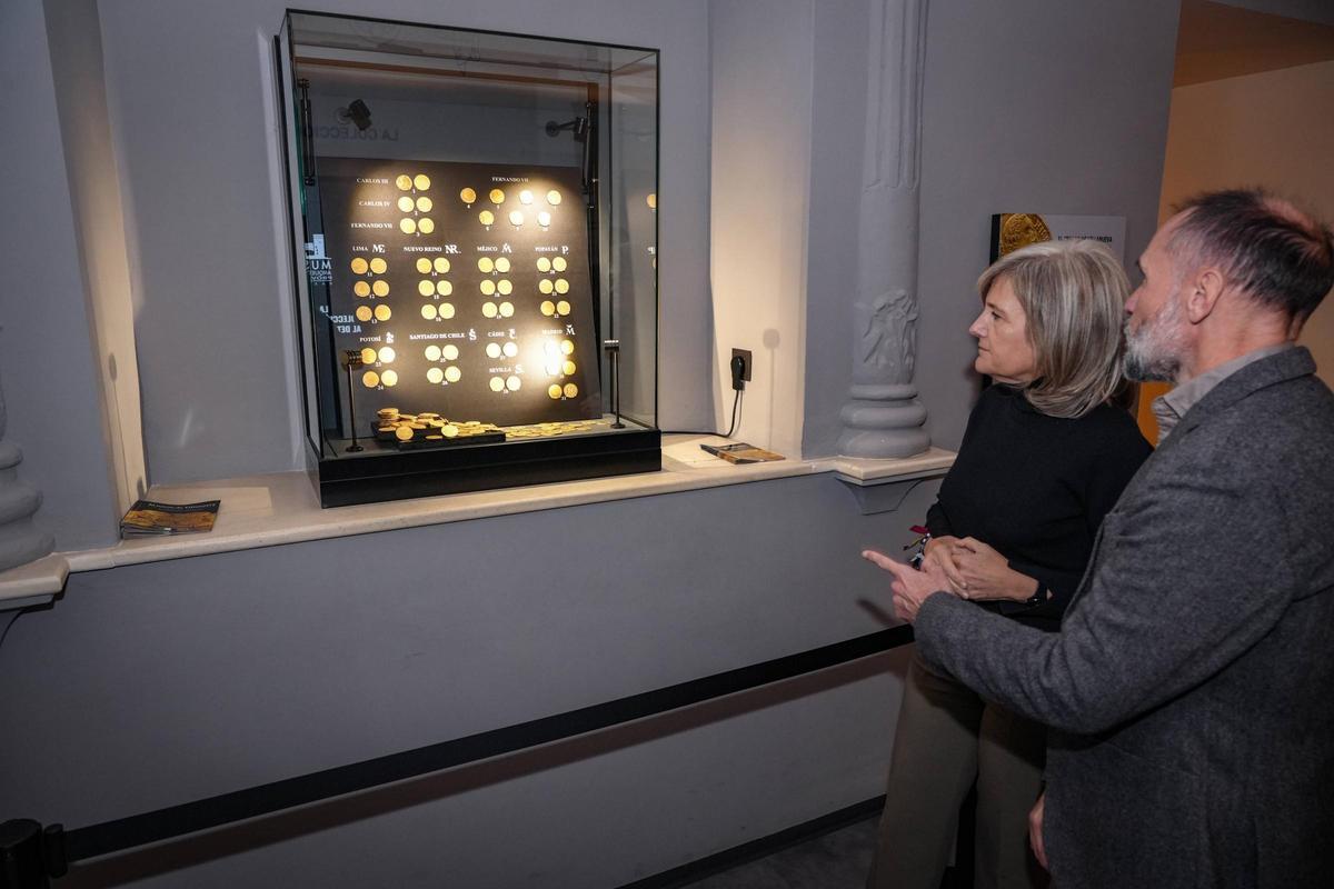La consejera de Cultura, Victoria Bazaga y el director del museo, Javier Heras, contemplan las monedas.