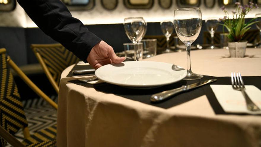 Un camarero prepara la mesa en un restaurante. La hostelería es uno de los sectores donde más tarde se pagan las facturas.