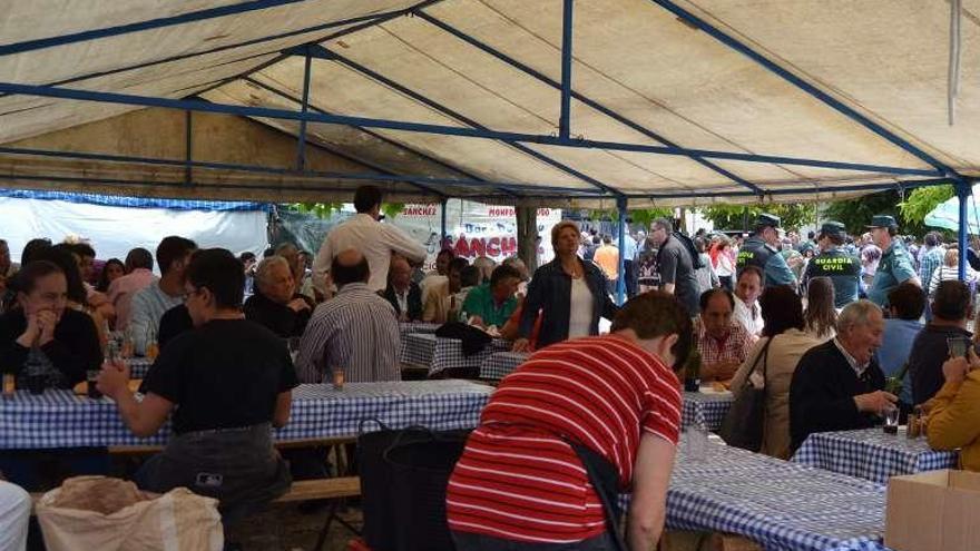 Comensales bajo una carpa en una feria de Porto.