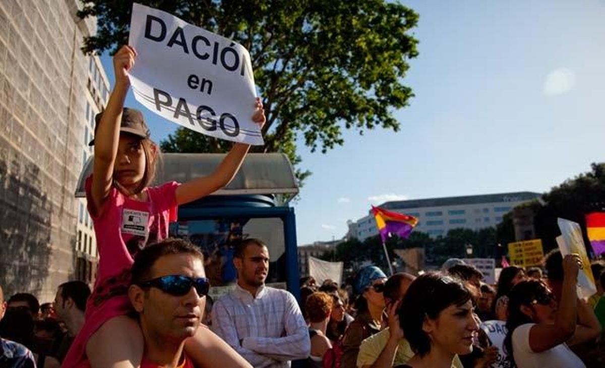 Una nena exhibeix un cartell a favor de la dació en pagament a la plaça de Catalunya.
