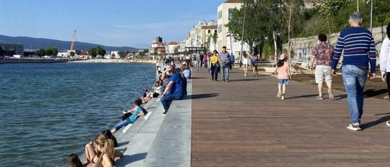 Ciudadanos disfrutan del paseo de Bouzas y la nueva grada entre la iglesia y la VG-20.