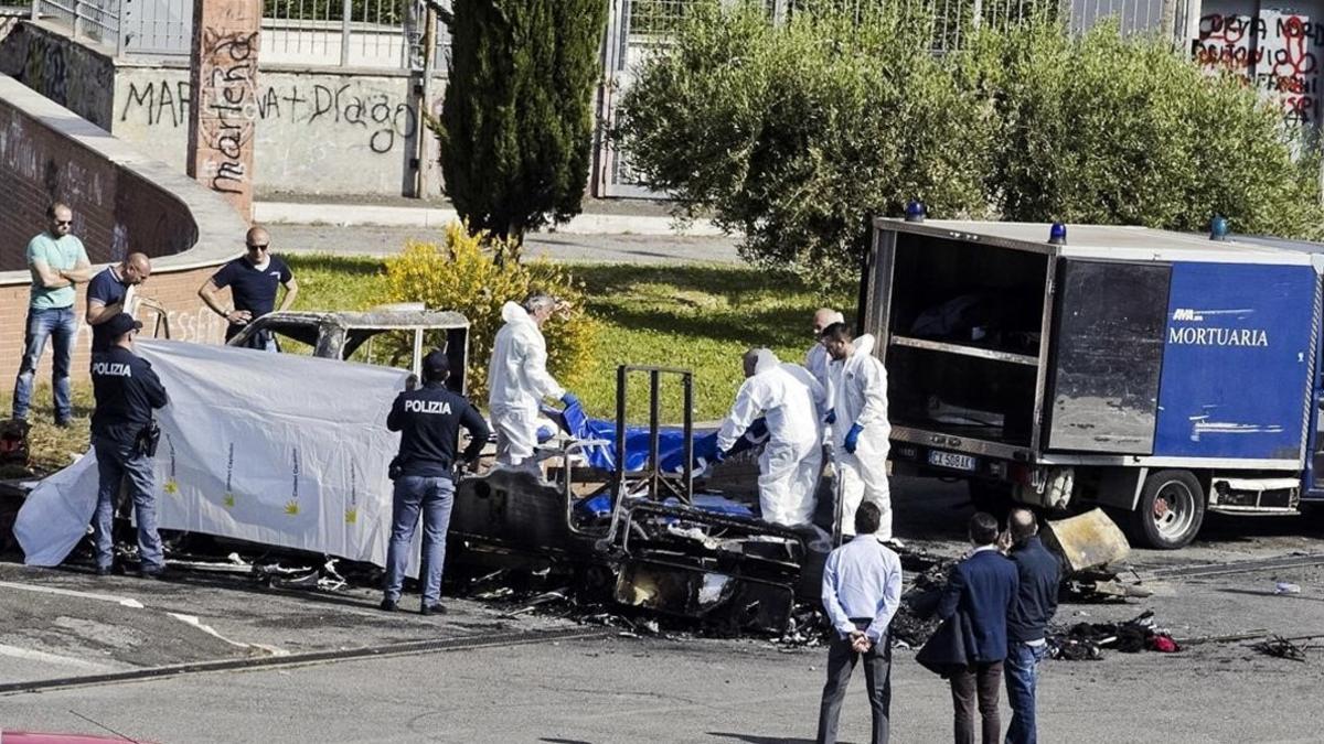 La policía forense cubre un cadáver sacado de la caravana donde murieron tres hermanas gitanas, en Roma, el 10 de mayo.