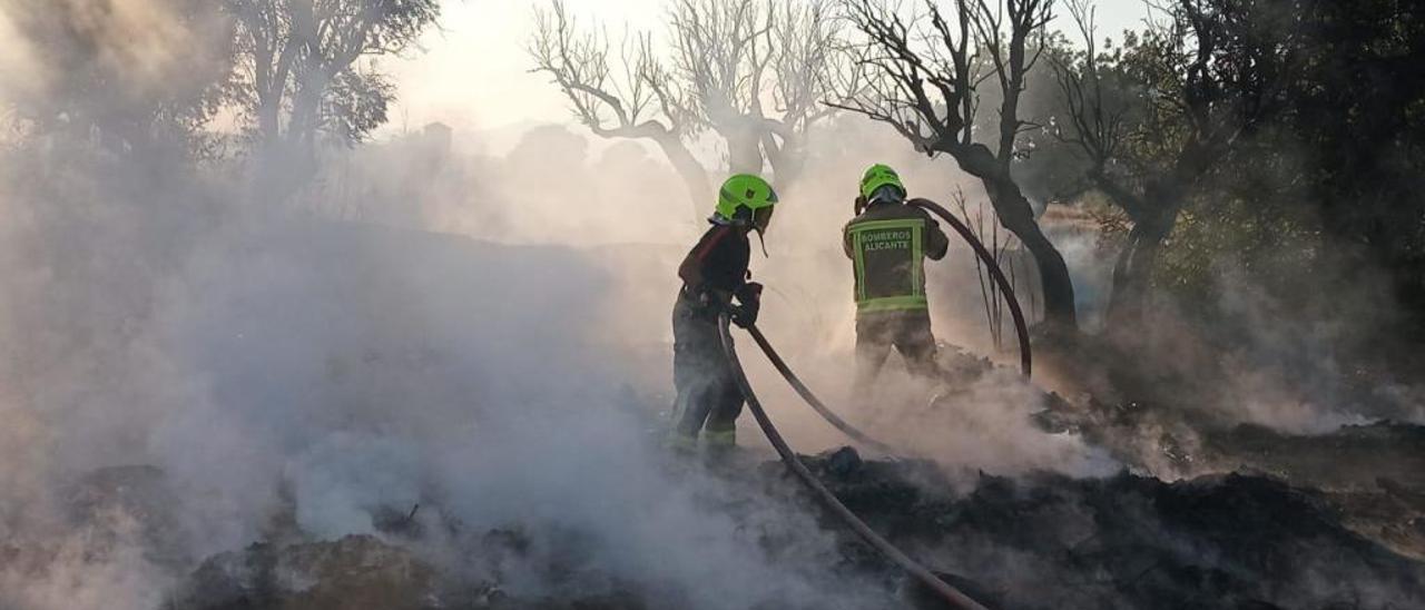 Dos bomberos participan en la extinción del incendio originado por la quema de rastrojos el pasado 17 de julio.