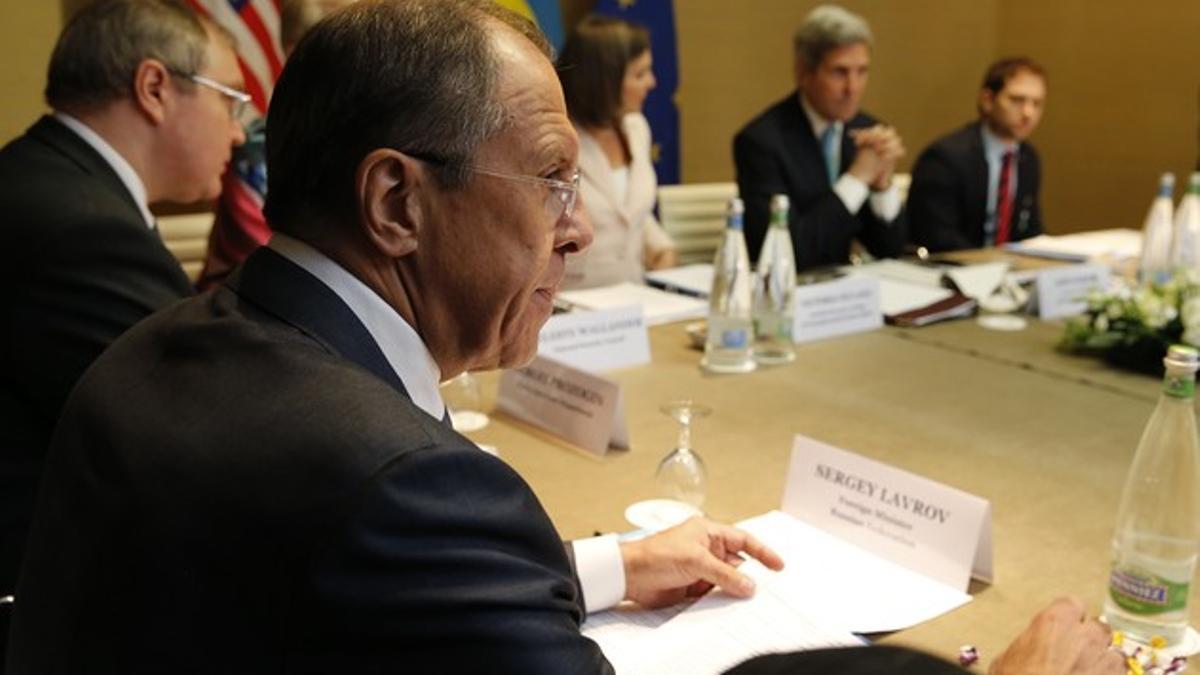 El ministro ruso de Exteriores, Serguei Lavrov, en primer término, y su homólogo estadounidense, John Kerry (al fondo), durante la reunión en Ginebra.