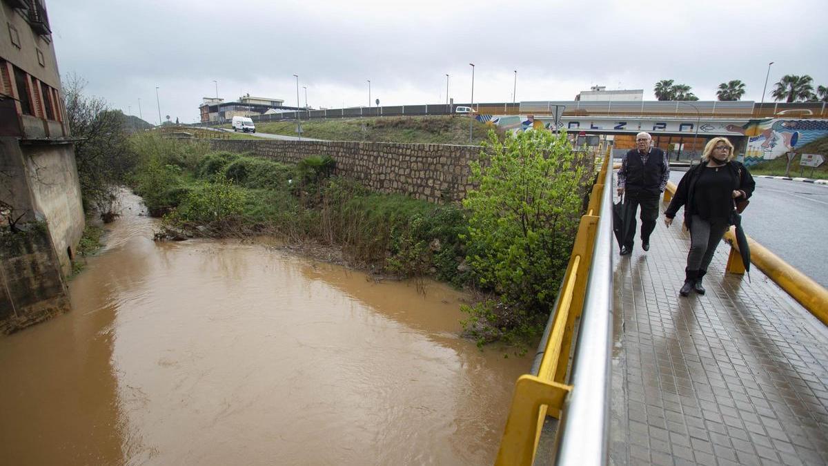 Dos peatones cruzan el Pont de Xàtiva sobre el barranco de la Casella, que será sustituido para mejorar la capacidad de desagüe.