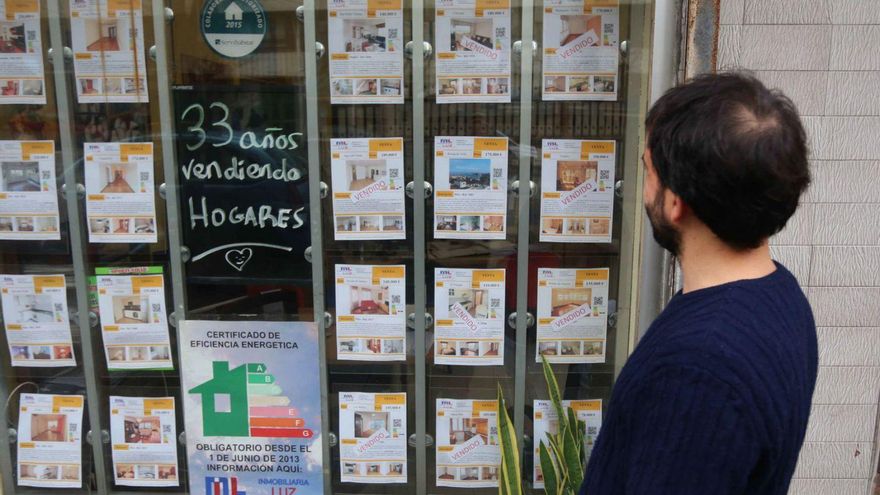 Un joven mira precios en una inmobiliaria de A Coruña. | Iago López
