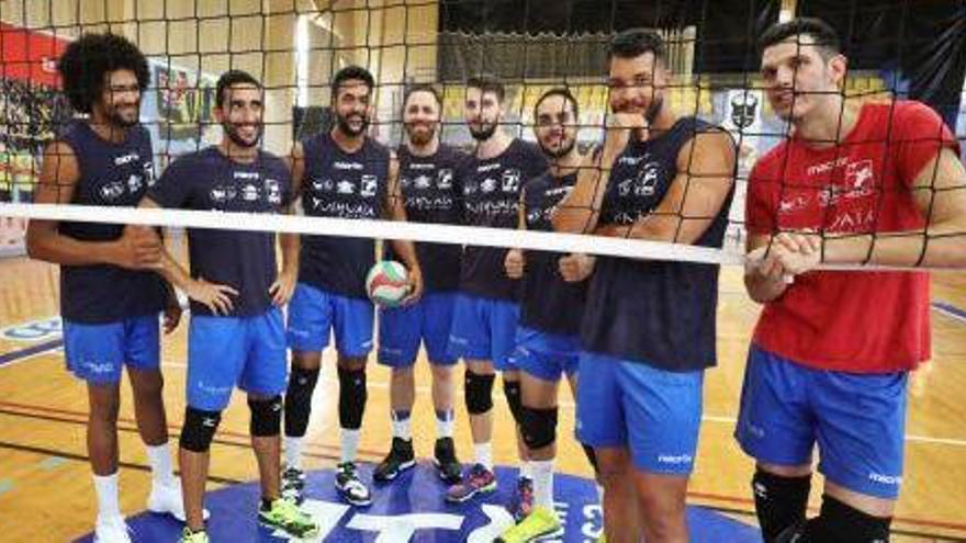 Los integrantes de la plantilla del Ushuaïa Ibiza Vóley posan junto a la red de forma divertida antes de su primer entrenamiento.