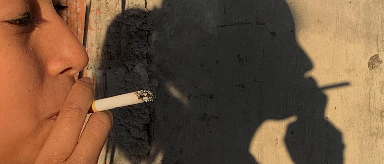 Una mujer le da una calada a un cigarrillo.