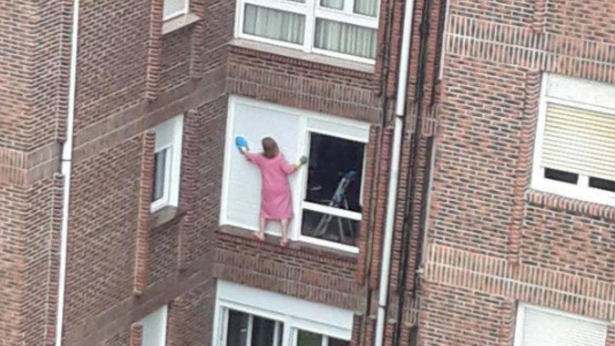 Una mujer limpiando las persianas de su casa