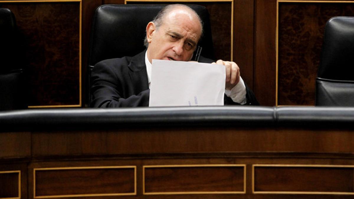 El ministro del Interior, Jorge Fernández Díaz, habla por teléfono en su escaño en el Congreso.