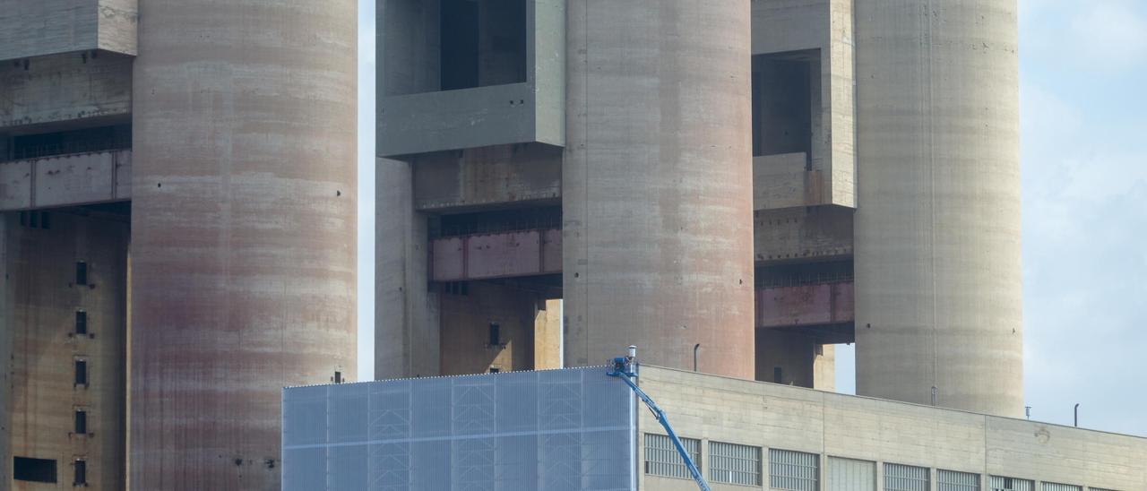 Obras de desamiantado este pasado verano en la nave de turbinas, con las Tres Xemeneies al fondo, en Sant Adrià de Besòs.