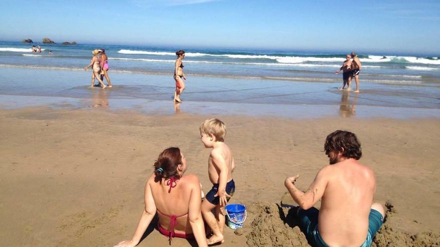 Una pareja con un niño, en la playa de Aguilar.