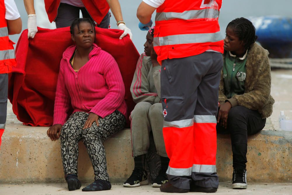 Migrants rest upon arriving on a rescue boat at ...