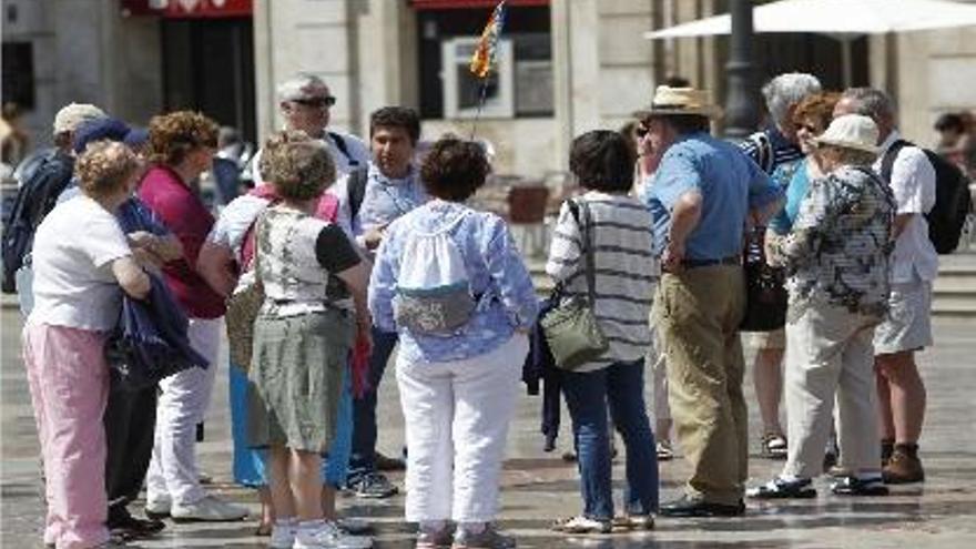 Un grupo de turistas atiende las explicaciones de un guía en el centro de Valencia.