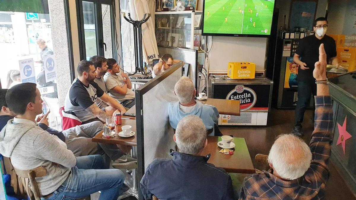 Clientes de un bar viento un partido del Celta en la televisión